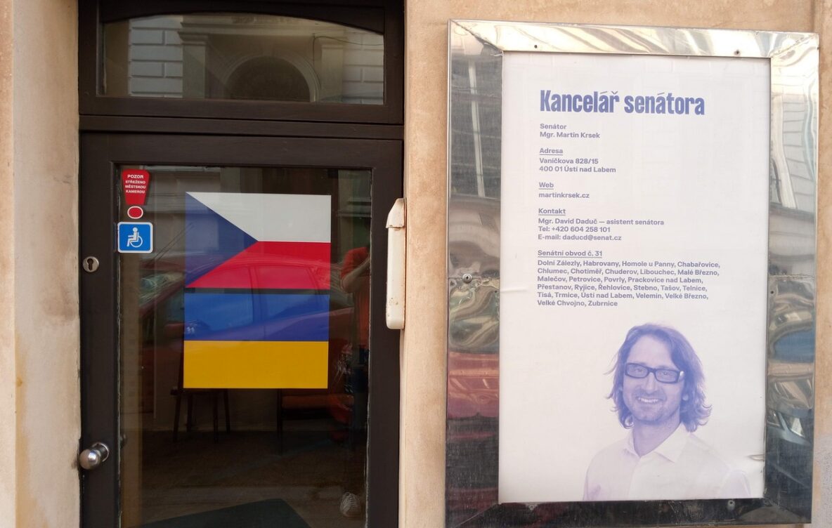 Česká a ukrajinská vlajka na dveřích regionální senátní kanceláře Martina Krska