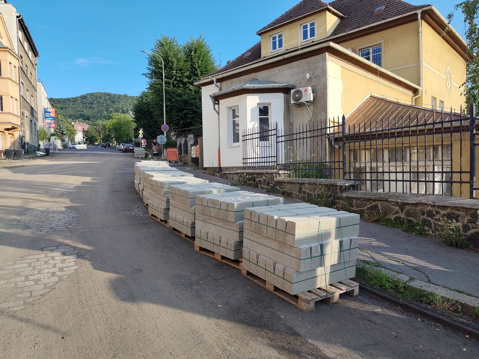 Rekonstrukce Žukovovy ulice. Je vidět původní žulové obrubníky a odkrytou dlažbu z žulových kostek. Na paletách jsou složené nové betonové obrubníky.